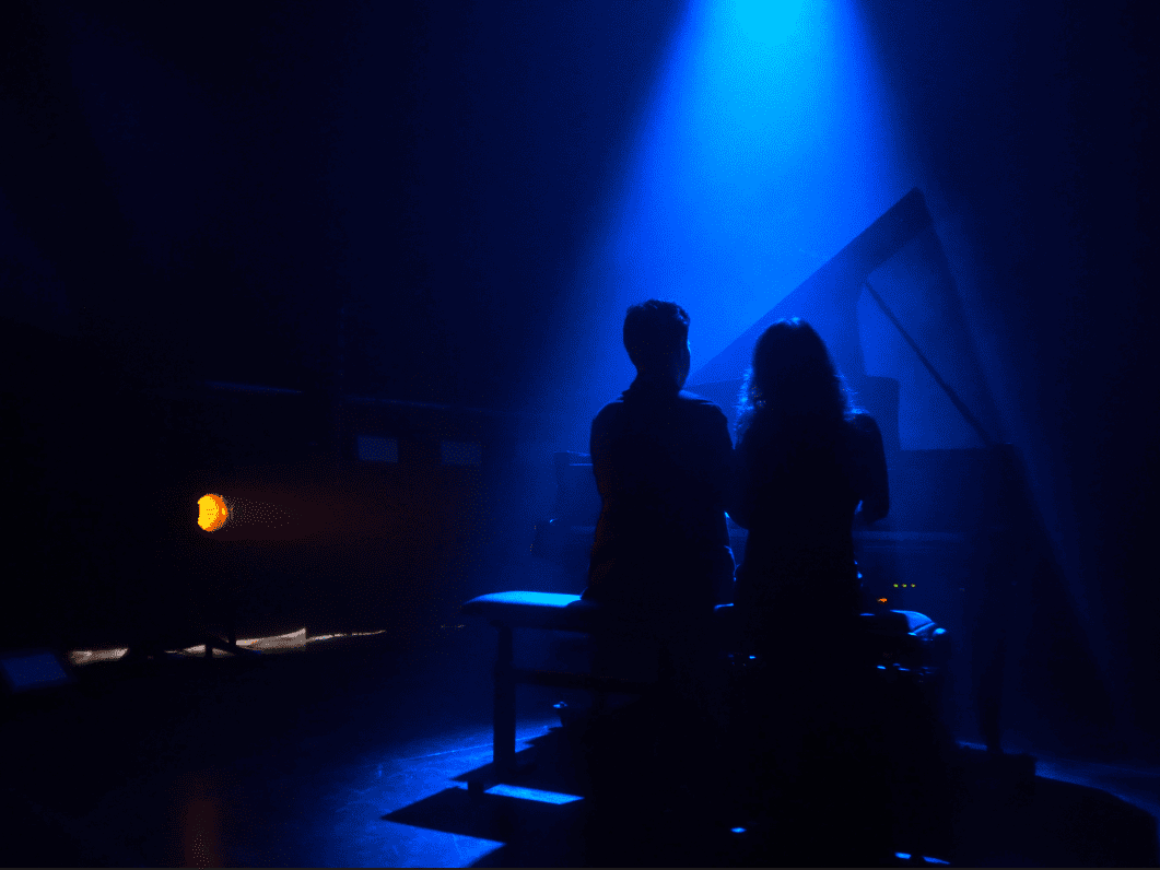 Ikigai Duo playing Momentum with blue light. View from the back